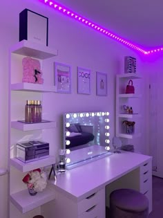 a white desk topped with a mirror and lots of purple lights in a room filled with furniture