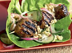 a plate with some meat and vegetables on top of lettuce leaf wrappers