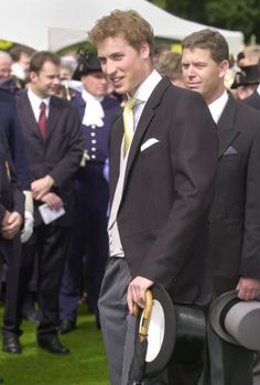 two men in suits and hats standing next to each other on the grass at an event