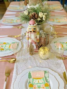 the table is set with plates, silverware and gold utensils on it