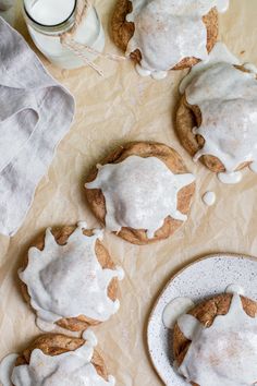 cookies with white icing and cinnamon on a table next to a glass of milk