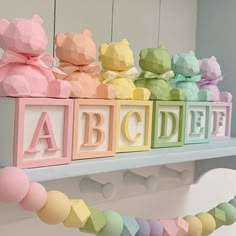 colorful wooden blocks spelling out the word abcdef on a white shelf with pink, yellow, green, and blue letters