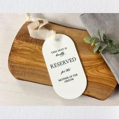 a wooden cutting board with a tag that says reserved on it and a cloth next to it