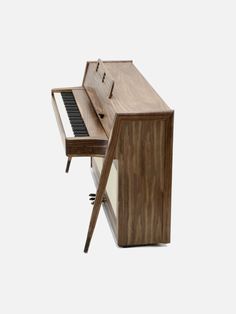 an old piano with a wooden stand and keyboard on it's side, in front of a white background