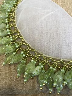 a green beaded necklace on top of a pillow