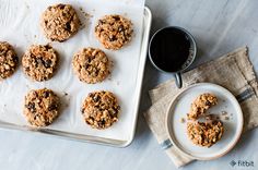 cookies on a tray next to a cup of coffee and napkin with a spoon in it