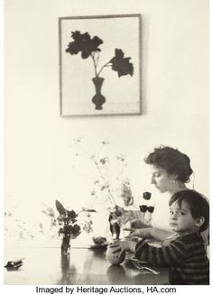 two children sitting at a table with flowers