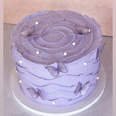 there is a purple cake with butterflies on it