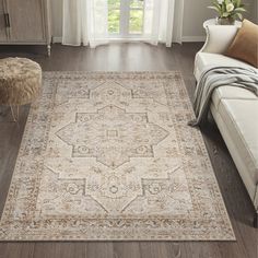 a living room area with a couch, chair and large rug on the hardwood floor