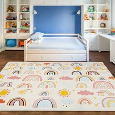 a child's bedroom with blue walls, white furniture and a rainbow rug on the floor