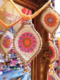 several crocheted ornaments hanging from a mirror