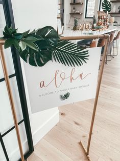 a sign that says aloha on it next to a table with some plants