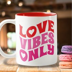 a pink and white coffee mug with the words love vibes only on it