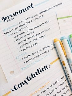 two pens sitting on top of a piece of paper next to each other with writing on it