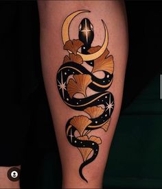 a tattoo on the leg of a person with a snake and moon in their legs