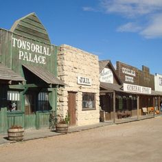 an old western town with stone buildings and green shutters