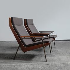 three chairs sitting side by side in an empty room with concrete flooring and gray walls