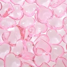 pink and white glass hearts are scattered on the ground, as if they were floating or floating in water