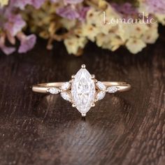 a close up of a ring on a wooden surface with flowers in the background and text romantic