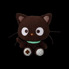 a brown cat stuffed animal sitting on top of a black background