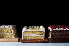 three different types of cakes on wooden trays with one slice missing from the cake