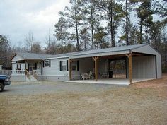 a truck is parked in front of a house with a carport and covered porch