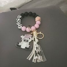 a tasseled keychain with an animal charm attached to it's side