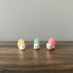 three small toy animals sitting on top of a wooden table