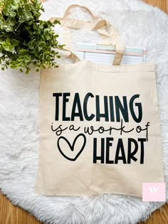 a tote bag with the words teaching is a work of heart printed on it