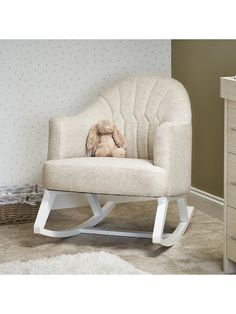 a white rocking chair with a stuffed animal on it's back in a room