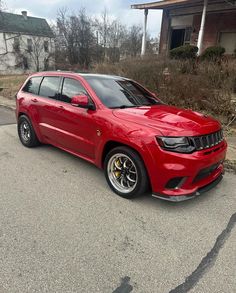 a red jeep is parked on the street