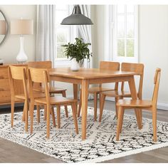 a dining room table and chairs with a rug on the floor