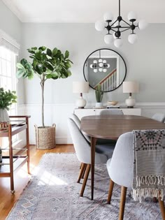 a dining room table with chairs and a rug on the floor in front of it