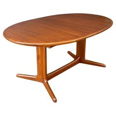 an oval wooden table with two legs and a circular wood table top on one end