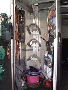 the inside of a van with various items in it and bags on the back wall