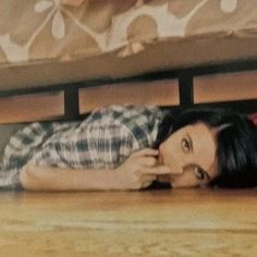 a woman laying on the floor in front of a bed