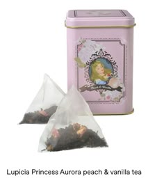 two bags of tea next to a pink tin with a princess image on the front