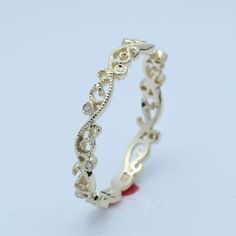 a gold ring with an intricate design on the inside and outside, sitting on a white surface