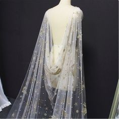 a mannequin wearing a white dress with gold stars on it's back