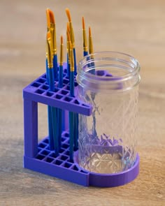 a jar filled with pens sitting on top of a wooden table