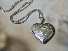 "This sweet silver heart locket necklace is a great keepsake necklace. It opens for your favorite two photographs. You will need to find a photo that fits and glue it into place. We do not place the photo in for you and at this time we do not engrave. Its the perfect gift for all ages I T E M * DETAIL: - PENDANT SIZE: Outside measurements 1 1/8\" x 1\", Inside measurement 7/8\" x 3/4\" - CHAIN LENGTH: 18\" Silver Link Chain over stainless steel C A R E * T I P S: We don't want your special momen Heart Locket Necklace Silver, Whimsical Wardrobe, Keepsake Necklace, Silver Heart Locket, Silver Locket Necklace, Silver Link Chain, Soft Boy, Heart Locket Necklace, Necklace Ideas