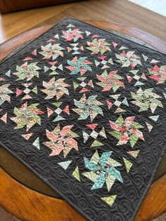 a quilted table topper on a wooden table