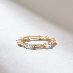 a close up of a gold ring on a white surface with light shining in the background