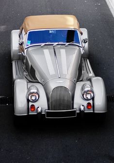 an old fashioned car is parked on the street