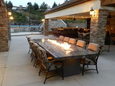 an outdoor dining area with fire pit and patio furniture