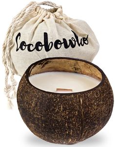 a coconut candle in a bag with the word cocobowe written on it next to an open coconut