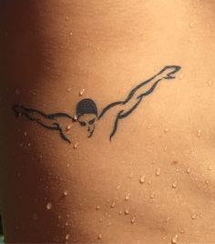 a woman's back with water drops on it and a tattoo that looks like a swimmer