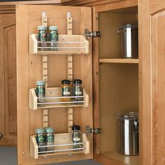 an open cabinet with spice racks in it