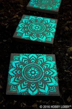 two wooden blocks with glow in the dark designs on them, one is green and the other is black