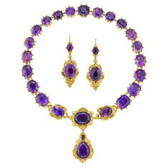 A late Georgian amethyst suite, the necklace centrally set with three oval faceted amethysts within gold scroll decorations, suspending a detachable drop with a pear-shaped and a small oval amethyst on a similar surround, attached to nineteen cushion and oval-cut faceted amethysts all set in closed-back collets, with a hidden snap clasp, accompanied by drop earrings of matching design, with gold wire fitting, all mounted in yellow gold, circa 1830, the necklace measuring approximately 41 x 6.3cm Luxury Heirloom Jewelry For Evening, Luxury Exquisite Purple Jewelry, Luxury Victorian Amethyst Necklace, Luxury Heirloom Purple Necklace, Luxury Victorian Purple Jewelry, Luxury Ornate Purple Jewelry, Luxury Ornate Purple Necklace, Luxury Collectible Amethyst Jewelry, Luxury Amethyst Jewelry For Evening